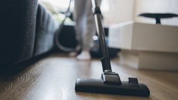 Personne en train de passer l'aspirateur dans la maison